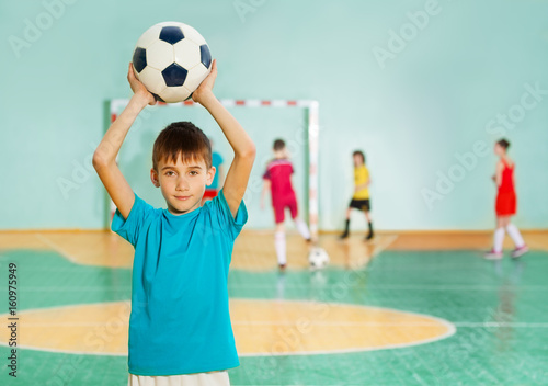 Boy tossing soccer ball during football match