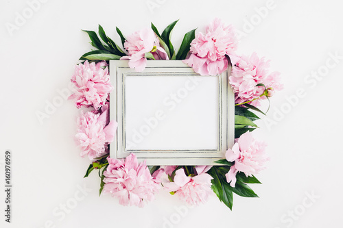 Fototapeta Naklejka Na Ścianę i Meble -  Pastel wooden frame decorated with peonies flowers, space for text. mock up