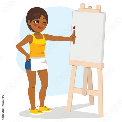 Young African American girl standing painting on white blank canvas