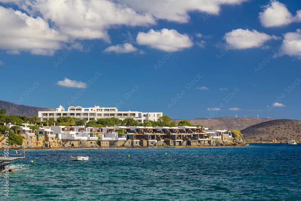 A large hotel by the sea. A boat is visible. Good weather. Day. Gulf of Mirabelo. Crete. Greece