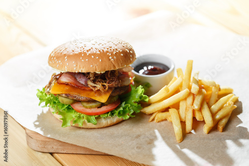 Big tasty burger and fries on the wooden table
