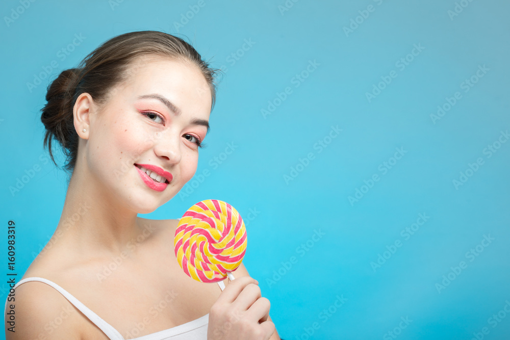 fun girl with candy on blue background