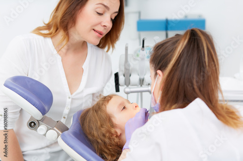 Dentists making treatment for little girl