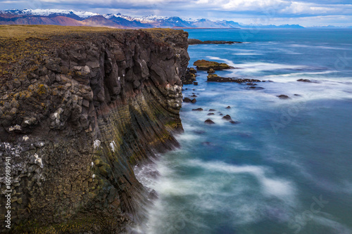 Cliffs washed by waves near Gatklettur arch rock in Snæfellsjökull, Iceland