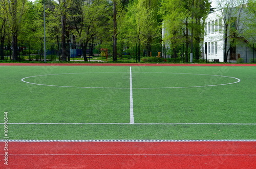 football field with artificial turf, central circle, background