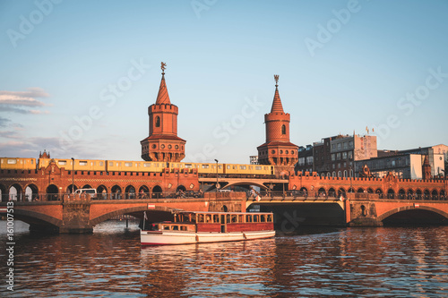 Oberbaumbruecke / Oberbaum Bridge and boat on river Spree in Berlin, Germany