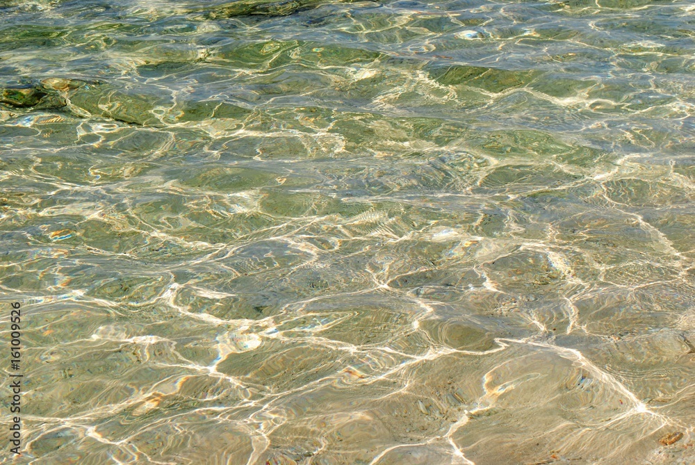 The soft clear sands of the beach visible through the crystal clear waters The soft clear sands of the beach visible through the crystal clear waters