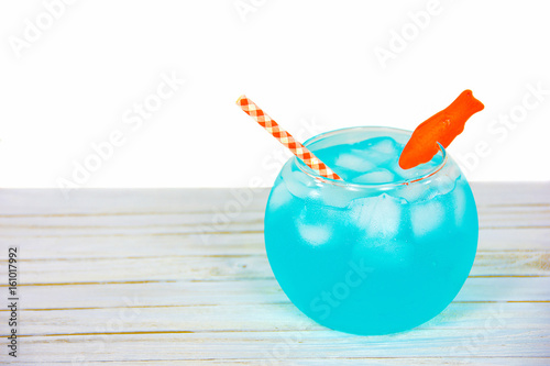 Foto blue cocktail drink in fishbowl with candy goldfish garnish and gingham orange a