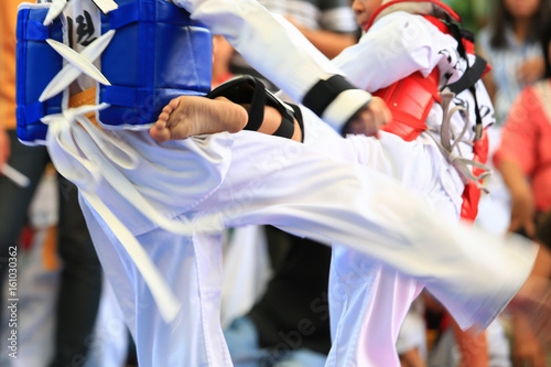 Taekwondo athletes fighting on stage © Sura Nualpradid