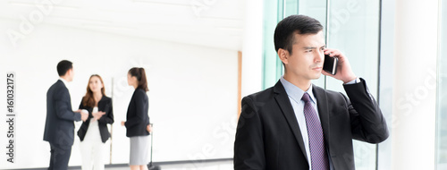 Businessman calling on smartphone at building hallway