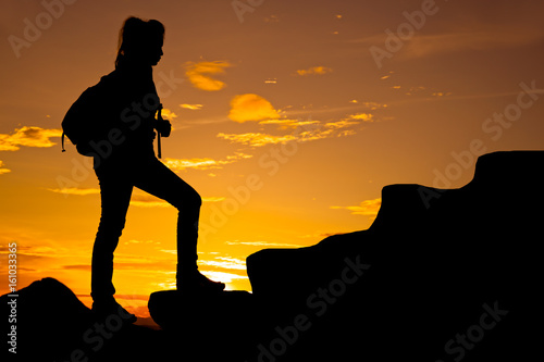 Woman with backpack running on top of mountain