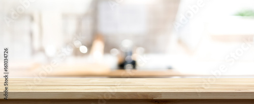 Wood countertop (or kitchen island) on blur kitchen interior background photo