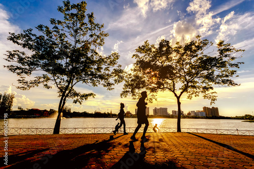 People jogging in park on sunset