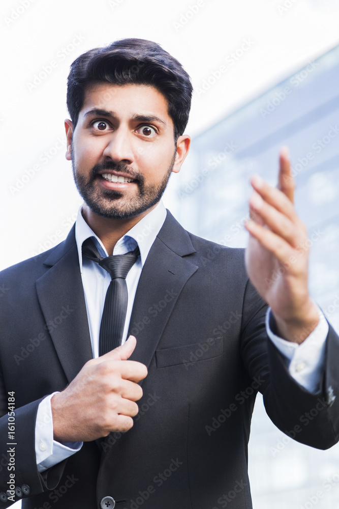 Angry businessman or worker standing in suit with hand raised Angry businessman or worker standing in suit with hand raised