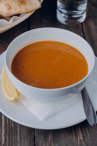 Vegetarian food concept. Lentil cream soup in white plate on wooden background table. Copy space. Healthy eating