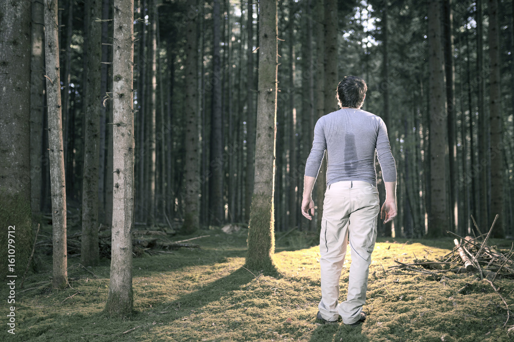 Exhausted man standing in the woods. Exhausted man standing in the woods.