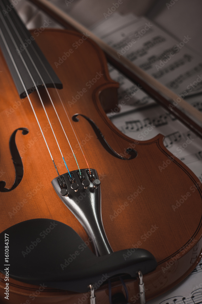 Fototapeta premium Old violin lying on the sheet of music, music concept