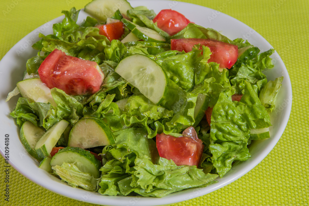 Fresh salad. Tomato, cucumber and greens in white bowl Fresh salad. Tomato, cucumber and greens in white bowl