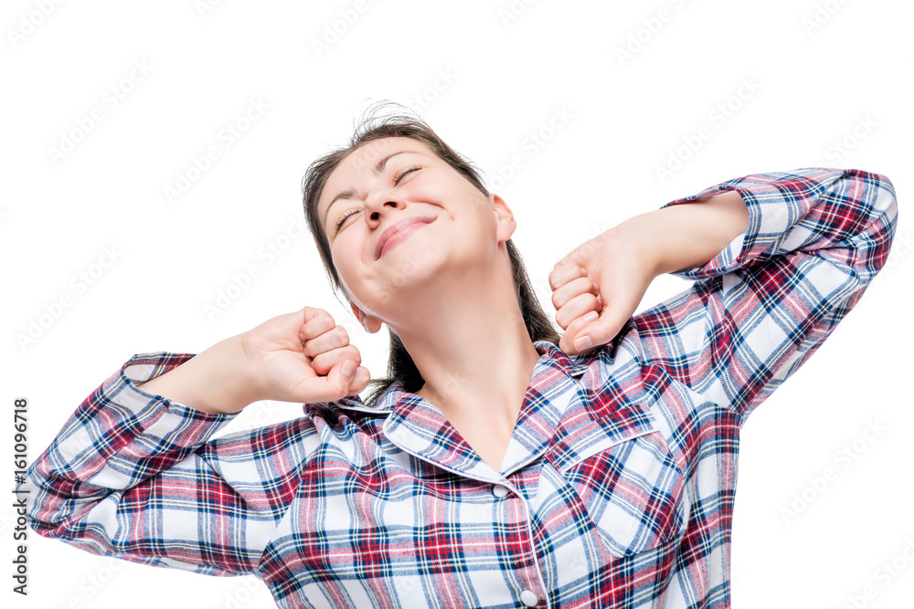 Woman in pajamas stretches after waking up in the morning on a white background Woman in pajamas stretches after waking up in the morning on a white background