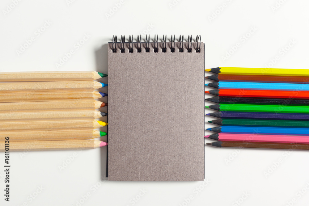 Obraz premium colored pencils and notepad on the table