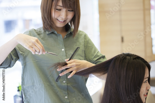 Hairdressers are cutting women's damaged hair