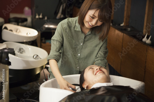 Hairdresser is washing female hair
