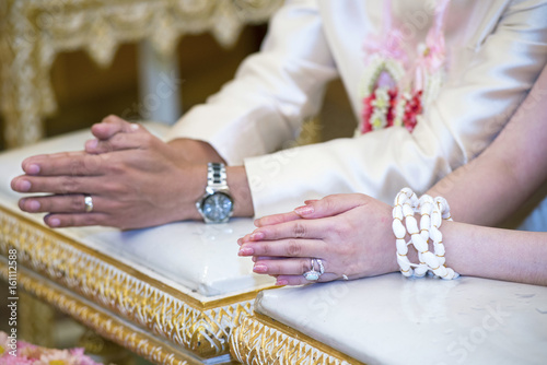 Hands pouring blessing water into bride's bands for the sacred ties of the couple in the wedding ceremony according to Thai traditional