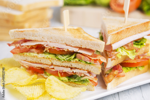Club sandwich on a rustic table in bright light