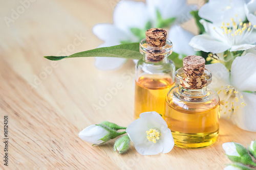 Bilde på lerret Essential oil in glass bottle with fresh jasmine flowers, beauty treatment