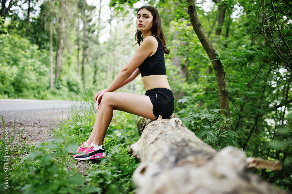 Sport girl at sportswear having rest in a green park after training at nature. A healthy lifestyle. Sport girl at sportswear having rest in a green park after training at nature. A healthy lifestyle.