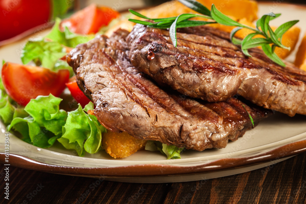 Succulent portions of grilled fillet mignon served with baked potatoes