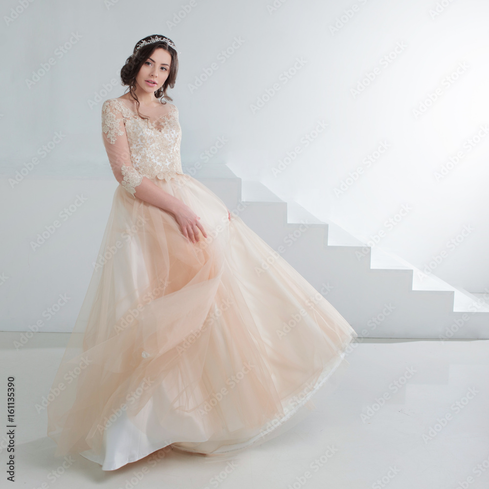 Portrait of a beautiful girl in a wedding dress. Bride in a luxurious dress, in a beautiful white interior Portrait of a beautiful girl in a wedding dress. Bride in a luxurious dress, in a beautiful white interior