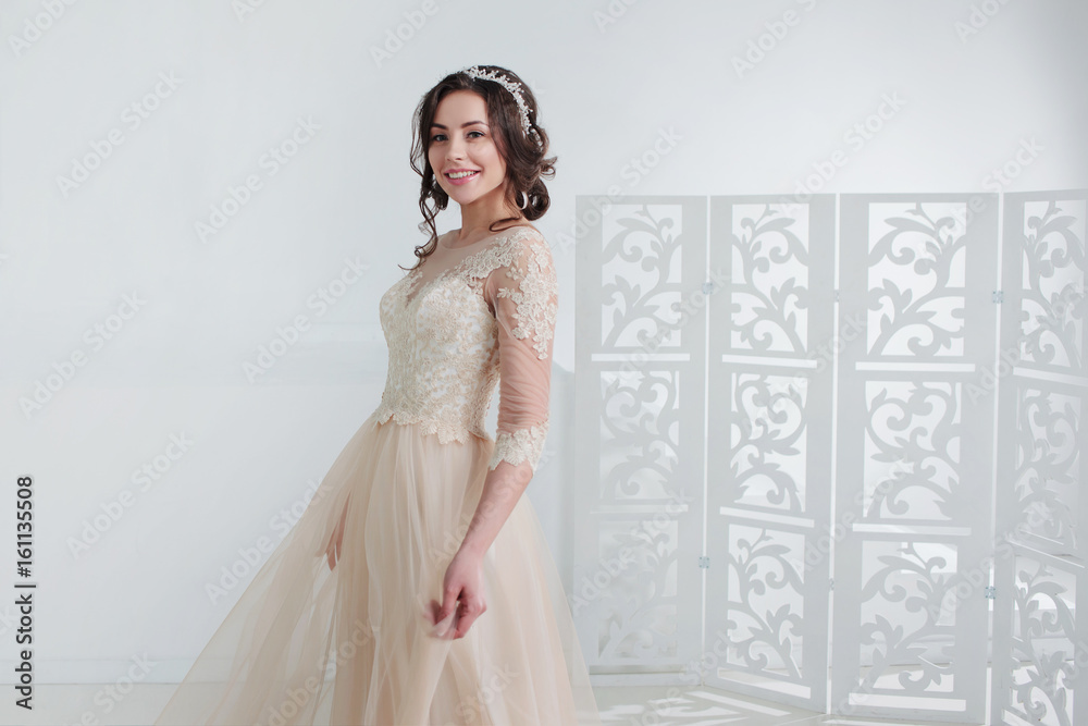 Portrait of a beautiful girl in a wedding dress. Bride in a luxurious dress, in a beautiful white interior