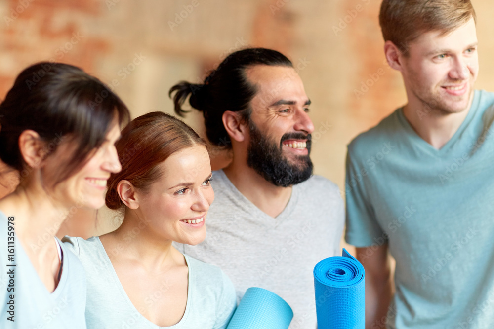 Obraz premium group of people with mats at yoga studio or gym