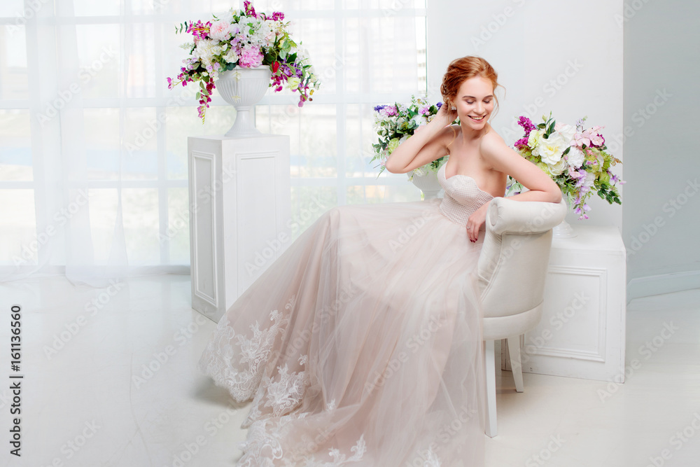 Portrait of a beautiful girl in a wedding dress. Bride in luxurious dress sitting on a chair Portrait of a beautiful girl in a wedding dress. Bride in luxurious dress sitting on a chair