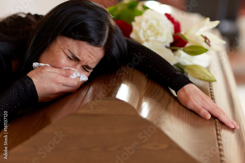 Foto woman with coffin crying at funeral in church