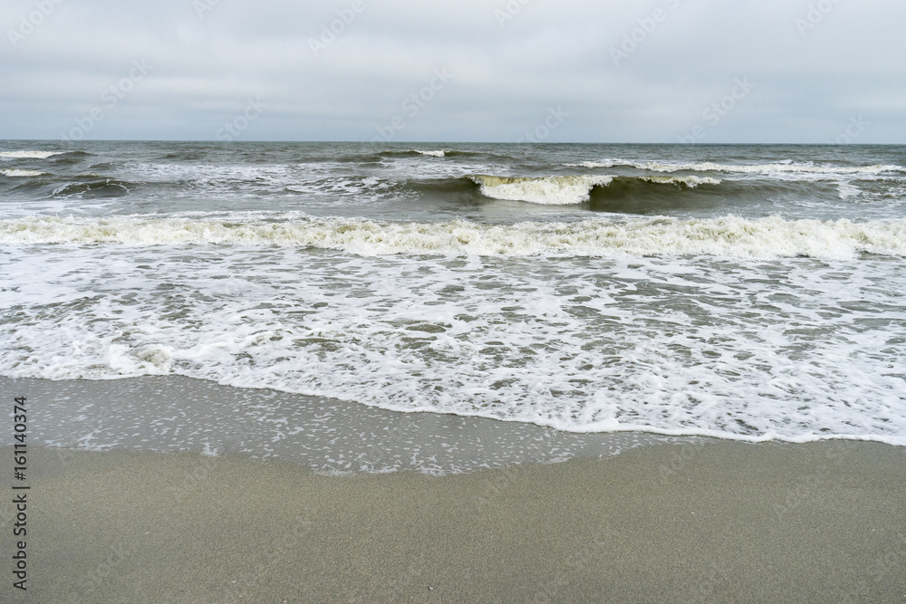 Fototapeta premium Landscape with The Black sea, sand and beach elements photographed in Gura Portitei, Romania, in a foggy spring day
