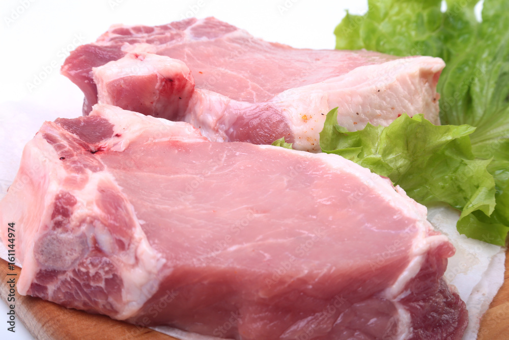 Raw pork chops with herbs and spices on cutting board. Ready for cooking. Raw pork chops with herbs and spices on cutting board. Ready for cooking.