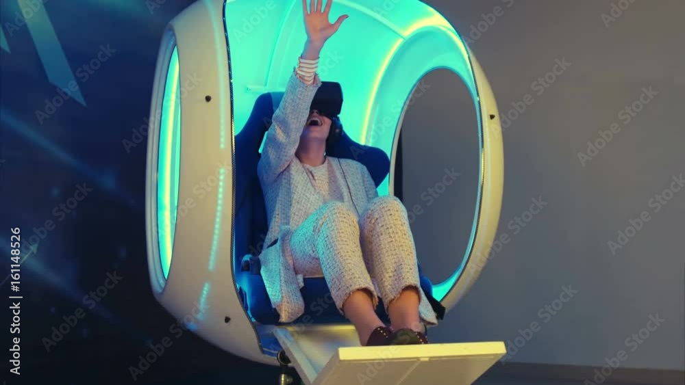 Emotional woman experiencing virtual reality in a moving interactive chair