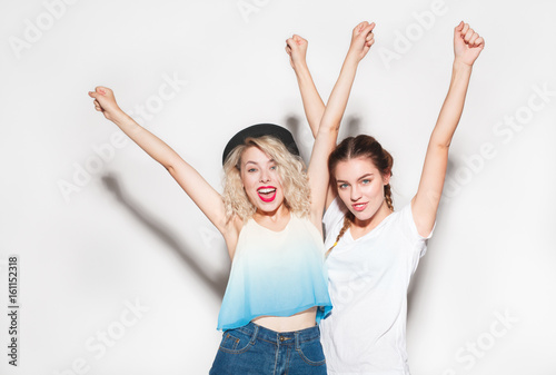 Cheerful girls posing on white