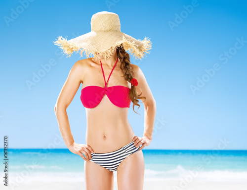 healthy woman on beach hide behind straw hat