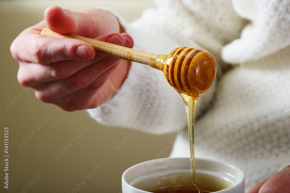 Spoon for honey with female hands Spoon for honey with female hands