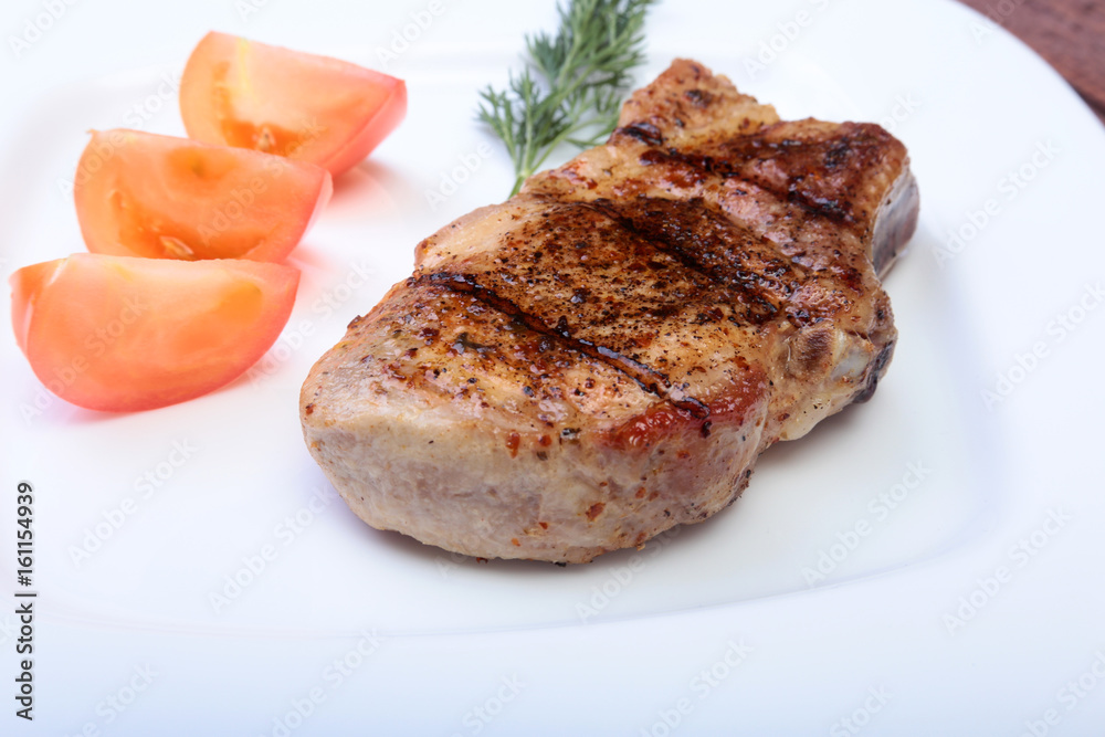 grilled pork chop with vegetable on plate on wooden board grilled pork chop with vegetable on plate on wooden board