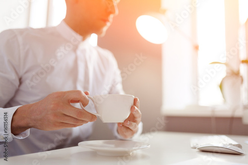 Man drinking coffee at desktop