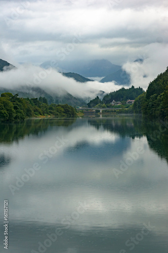 Mountain river landscape in the morning with low clouds and fog