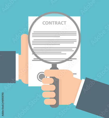 Contract inspection concept. Hand holding magnifying glass over a contract paper