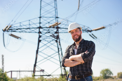 Engineer with white hard hat under the power lines.Engineer work at an electrical substation.
