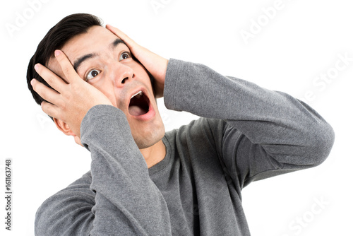 Foto Young man expressing shocked face with hand on his heads