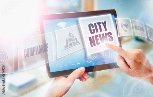 A businesswoman selecting a City News business concept on a futuristic portable computer screen. © Duncan Andison