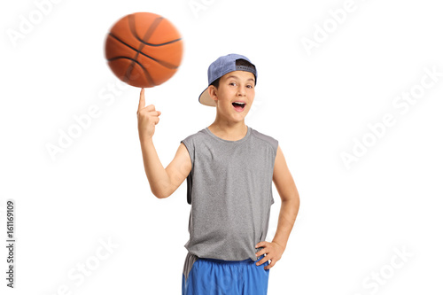 Joyful boy spinning a basketball on his finger